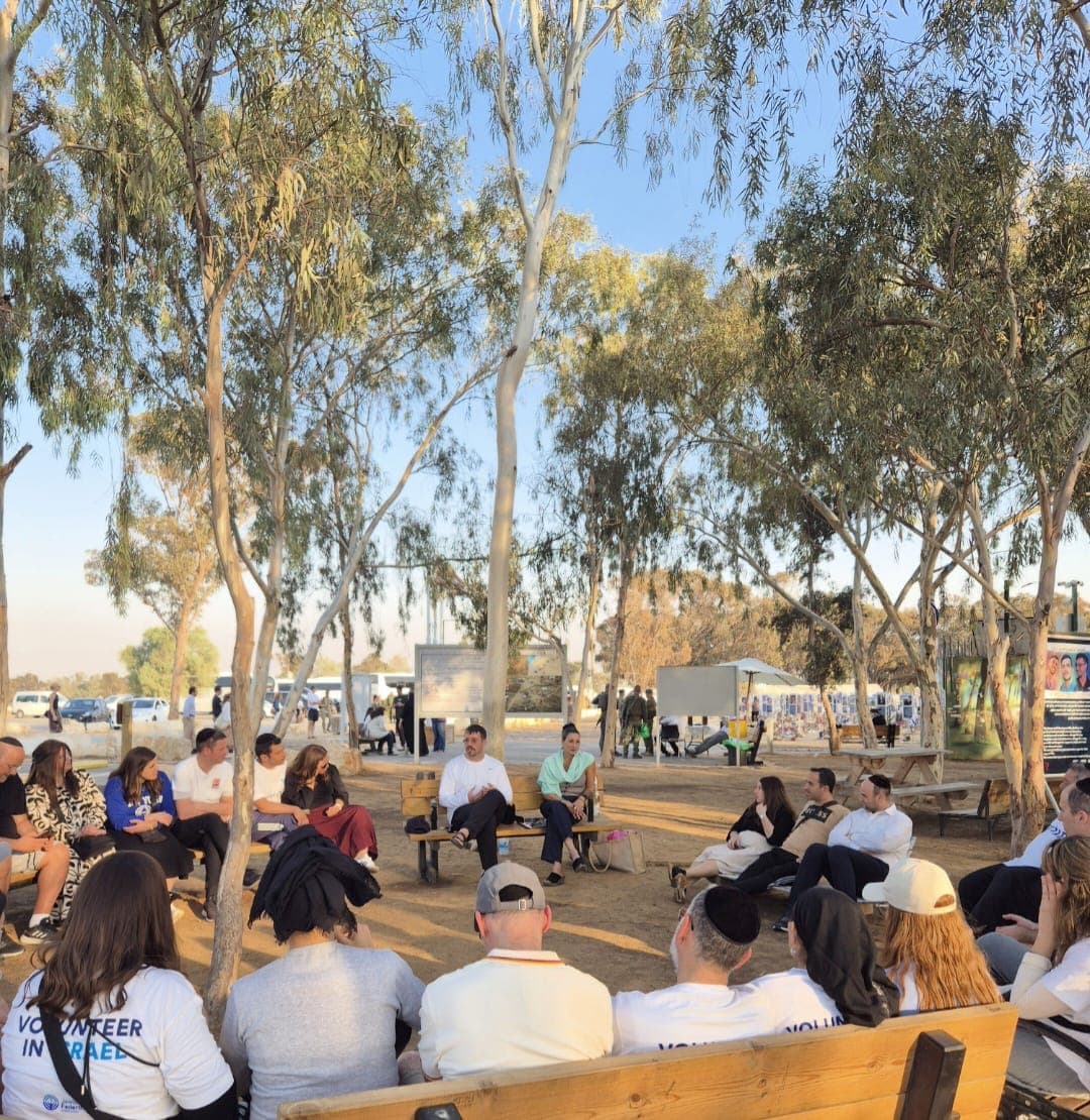 Volunteer group listening to testimony among the trees