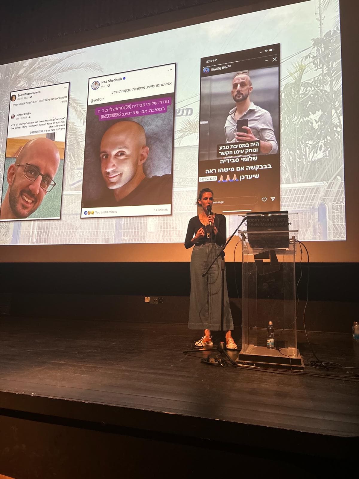 Family member sharing testimony on stage at the Tel Aviv Museum of Art